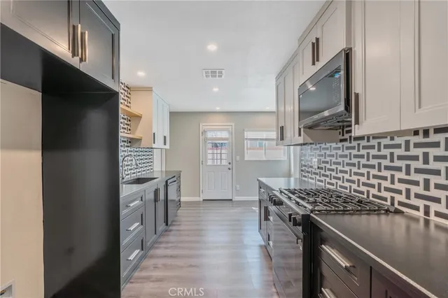 a kitchen with stainless steel appliances granite countertop a sink stove and refrigerator
