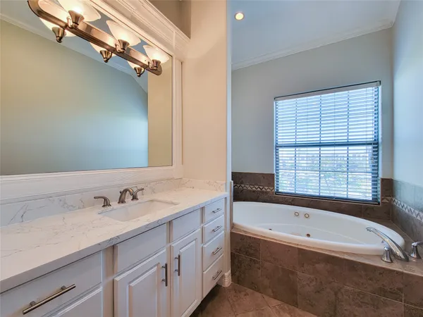 a bathroom with a tub sink and mirror