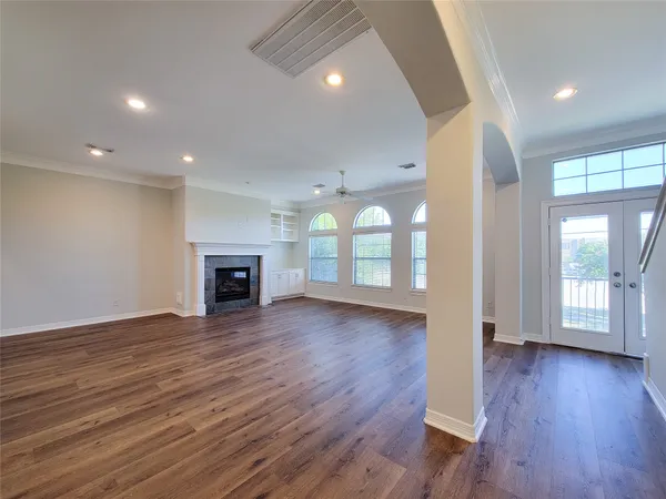 an empty room with wooden floor and fireplace