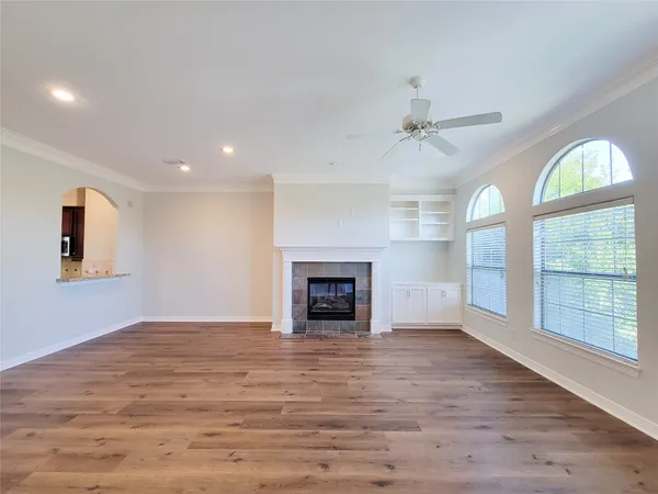 wooden floor fireplace and windows in an empty room
