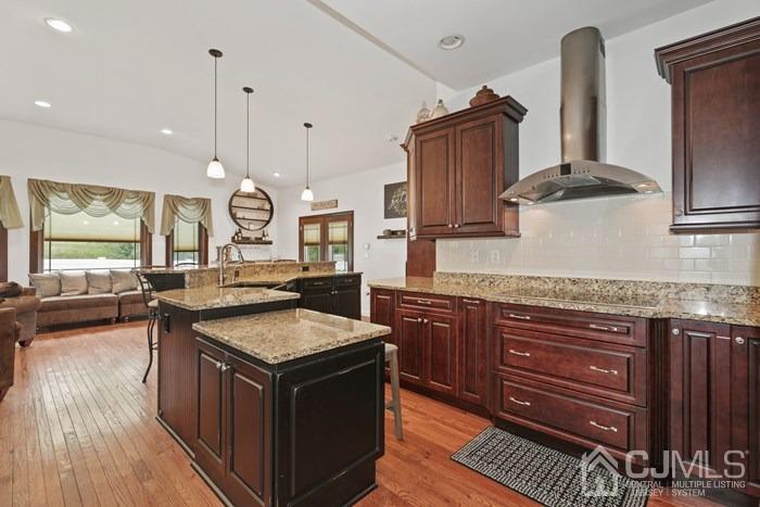 82 Brandywine Road Fords, NJ 08863 - Photo 4 of 26 a kitchen with granite countertop a stove a sink dishwasher and cabinets with wooden floor