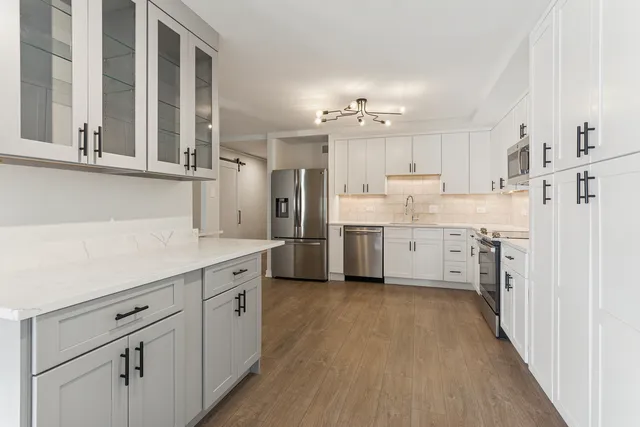 a kitchen with white cabinets and white appliances