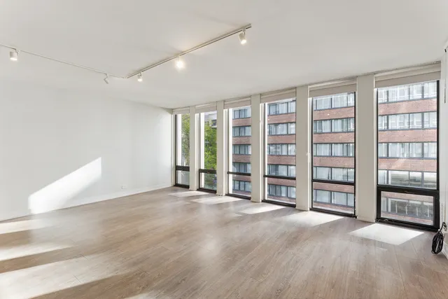 a view of an empty room with window and cabinet