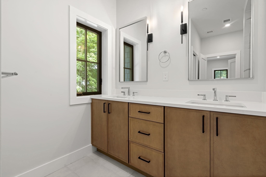 145 Warren Street, Unit 4 Newton, MA 02459 - Photo 21 of 35 a bathroom with a double vanity sink and mirror