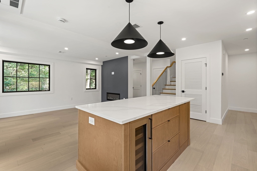 145 Warren Street, Unit 4 Newton, MA 02459 - Photo 7 of 35 a large kitchen with stainless steel appliances a large counter top space wooden floor and a chandelier