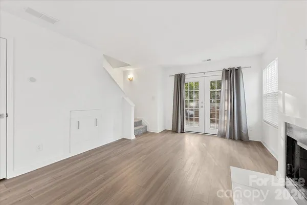 a view of an empty room with a fireplace and a window