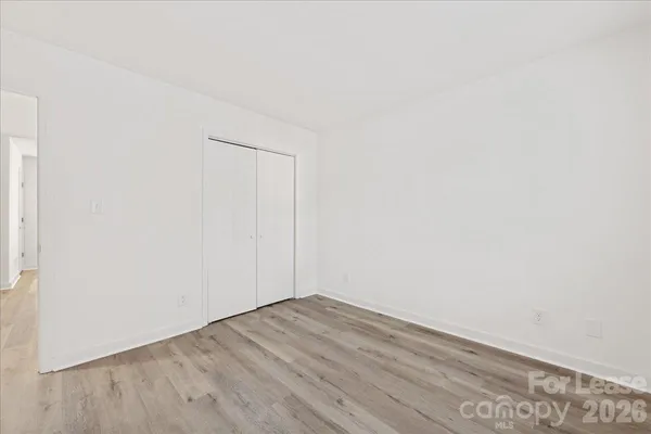 a view of empty room with wooden floor