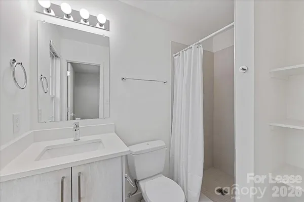 a bathroom with a toilet a sink a mirror and vanity