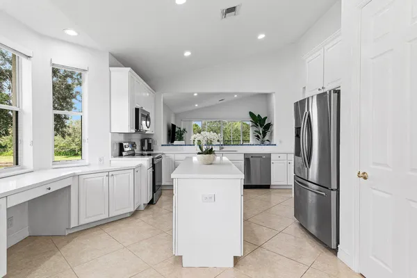 a kitchen with white cabinets and stainless steel appliances