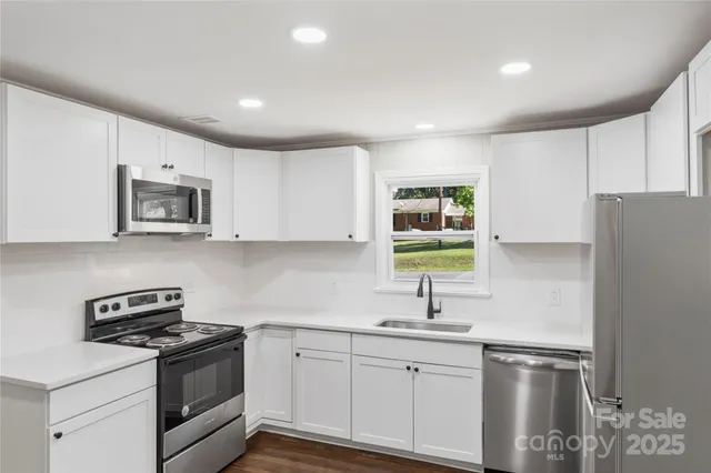 a kitchen with a refrigerator and a stove top oven