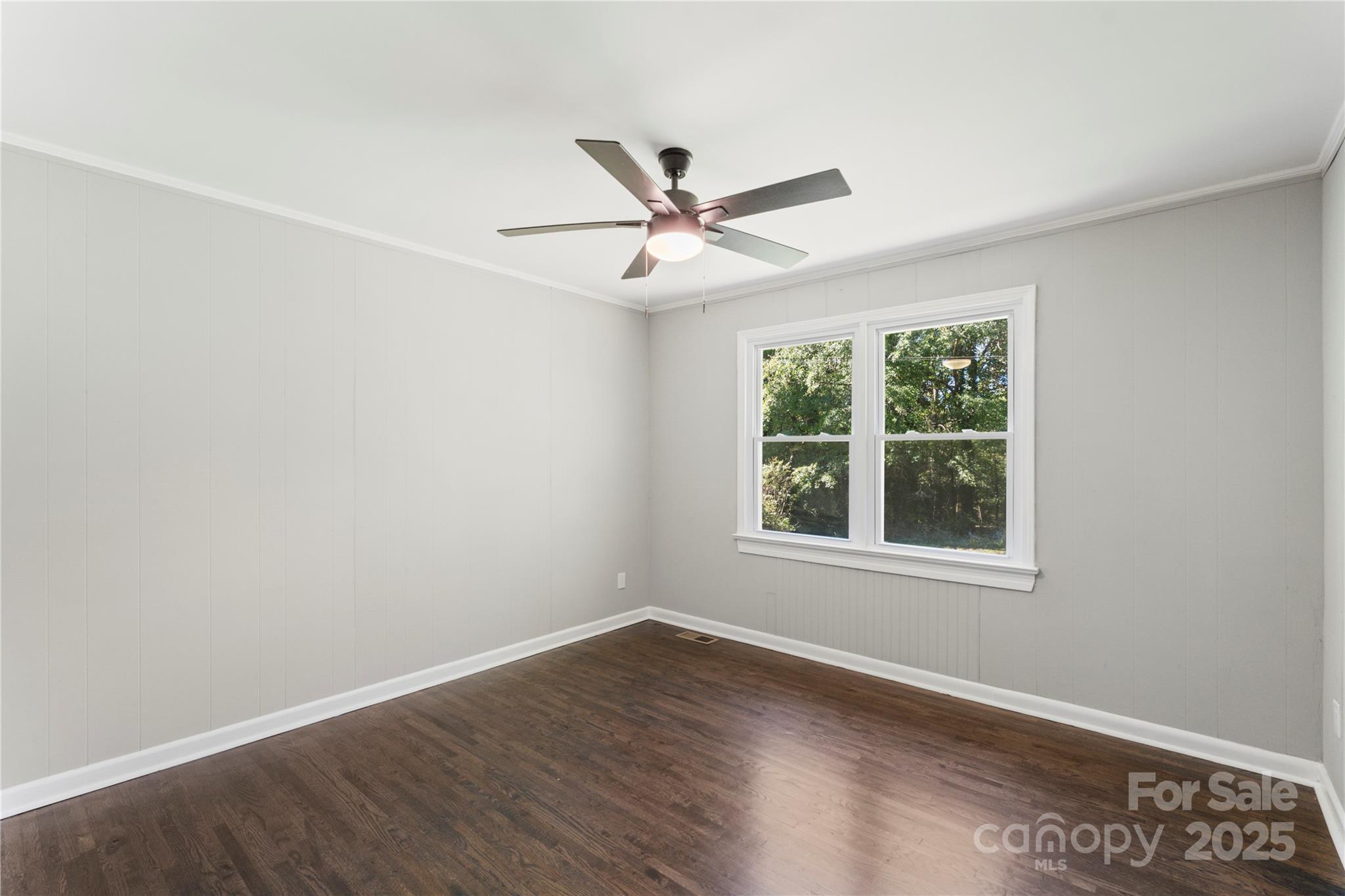 1428 Boxwood Avenue Lancaster, SC 29720 - Photo 29 of 44 an empty room with wooden floor ceiling fan and windows