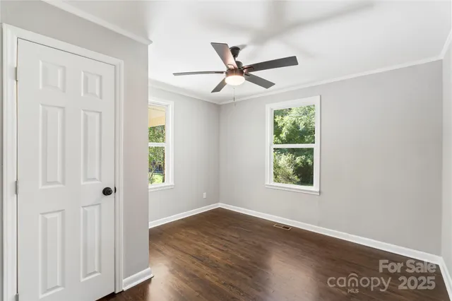 a view of an empty room with wooden floor