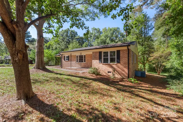 a view of a house with backyard and tree