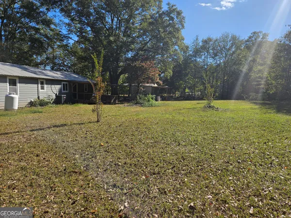 a view of yard with tree in the background