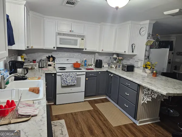 a kitchen with stainless steel appliances granite countertop a sink stove and cabinets