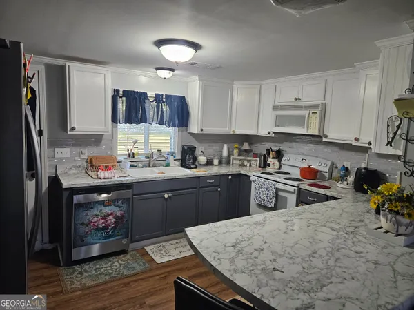 a kitchen with stainless steel appliances granite countertop a refrigerator stove top oven a sink and dishwasher