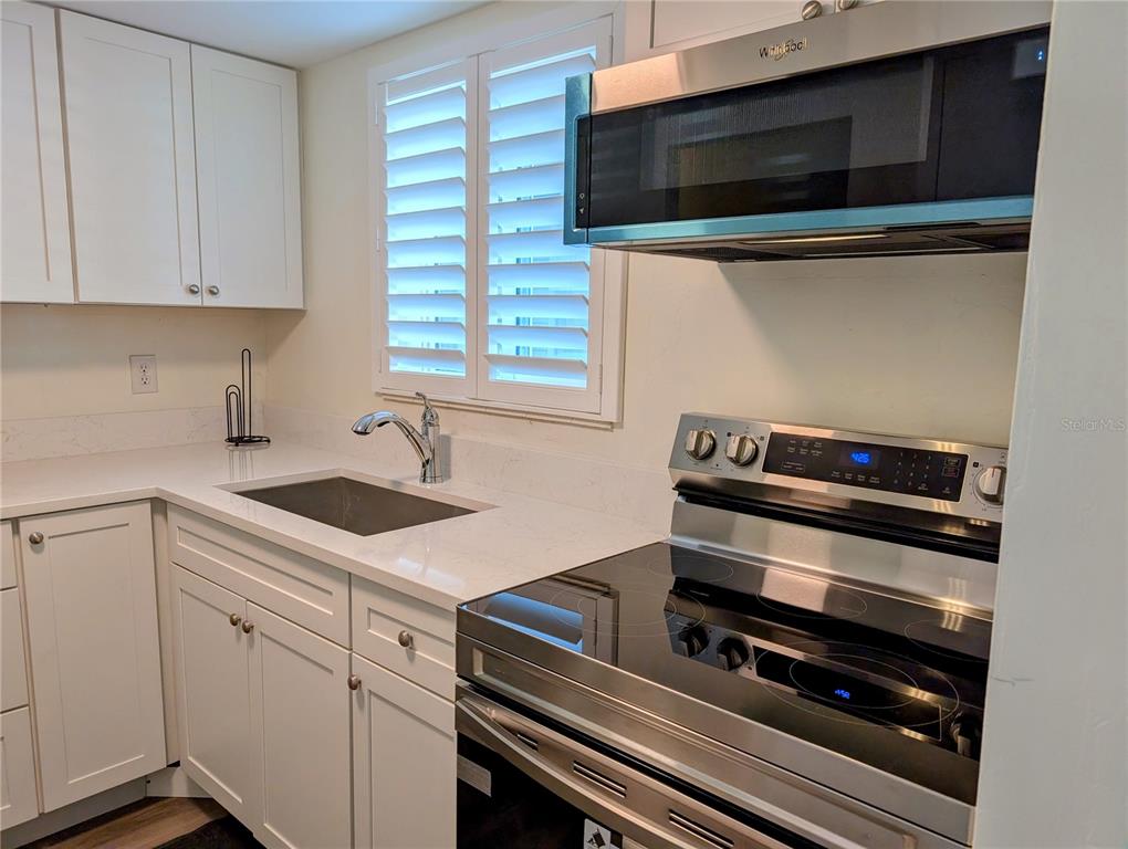5862 Welcome Road, Unit J25 Bradenton, FL 34207 - Photo 3 of 26 a kitchen with a stove and a microwave