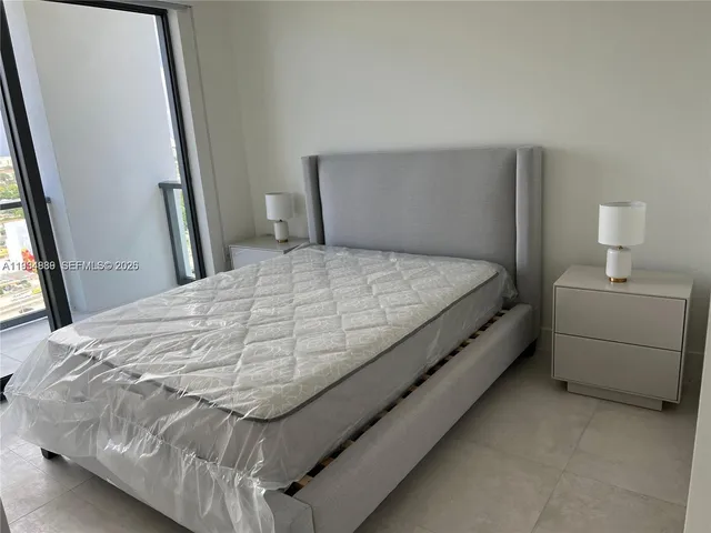 a bed sitting in a bedroom next to a window