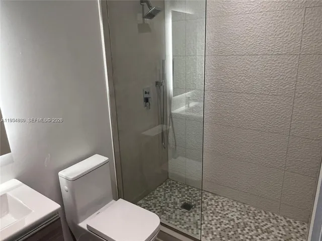 a bathroom with a toilet and a shower