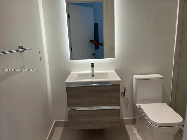 a bathroom with a sink toilet and mirror