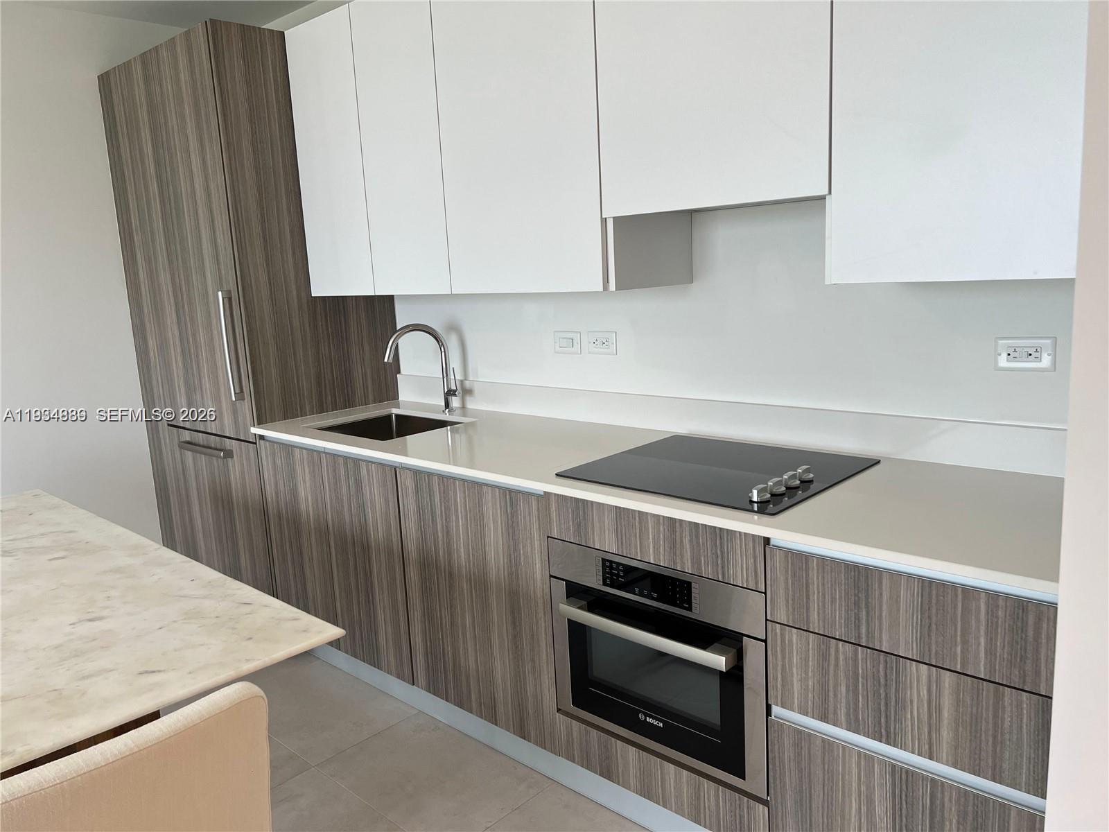239 Southwest 9th Street, Unit 2103 Miami, FL 33130 - Photo 6 of 14 a kitchen with stainless steel appliances a stove a sink and a refrigerator