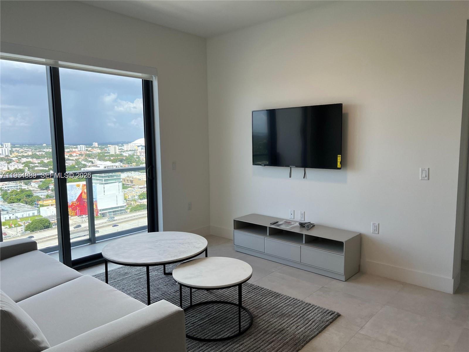 239 Southwest 9th Street, Unit 2103 Miami, FL 33130 - Photo 9 of 14 a living room with furniture and a flat screen tv