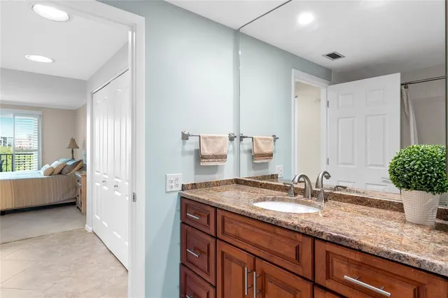a bathroom with a granite countertop sink and a mirror