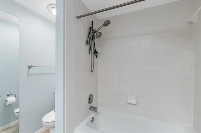 a bathroom with a granite countertop toilet a sink and shower