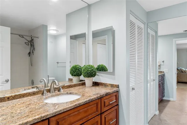 a bathroom with a granite countertop sink and a mirror
