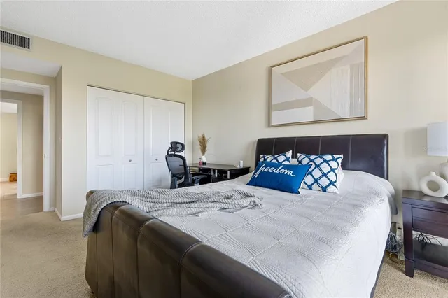 a bedroom with a bed and a painting on the wall