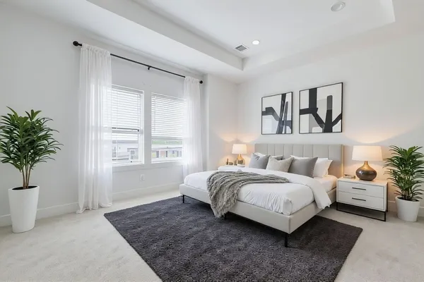 a living room with a bed furniture and potted plant