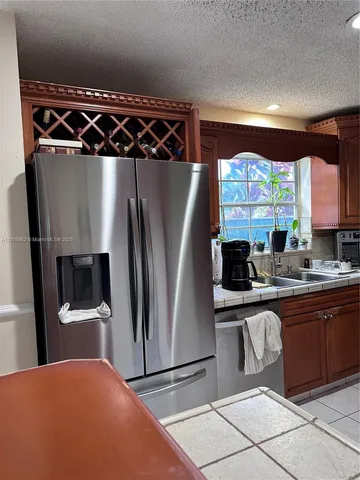a kitchen with stainless steel appliances granite countertop a refrigerator and a sink