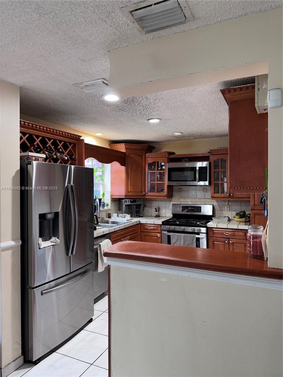 16215 Southwest 139th Court Miami, FL 33177 - Photo 12 of 31 a kitchen with stainless steel appliances granite countertop a refrigerator a stove top oven a sink and dishwasher