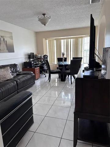 a living room with furniture a large window and a flat screen tv