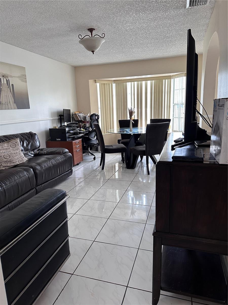 16215 Southwest 139th Court Miami, FL 33177 - Photo 9 of 31 a living room with furniture a large window and a flat screen tv