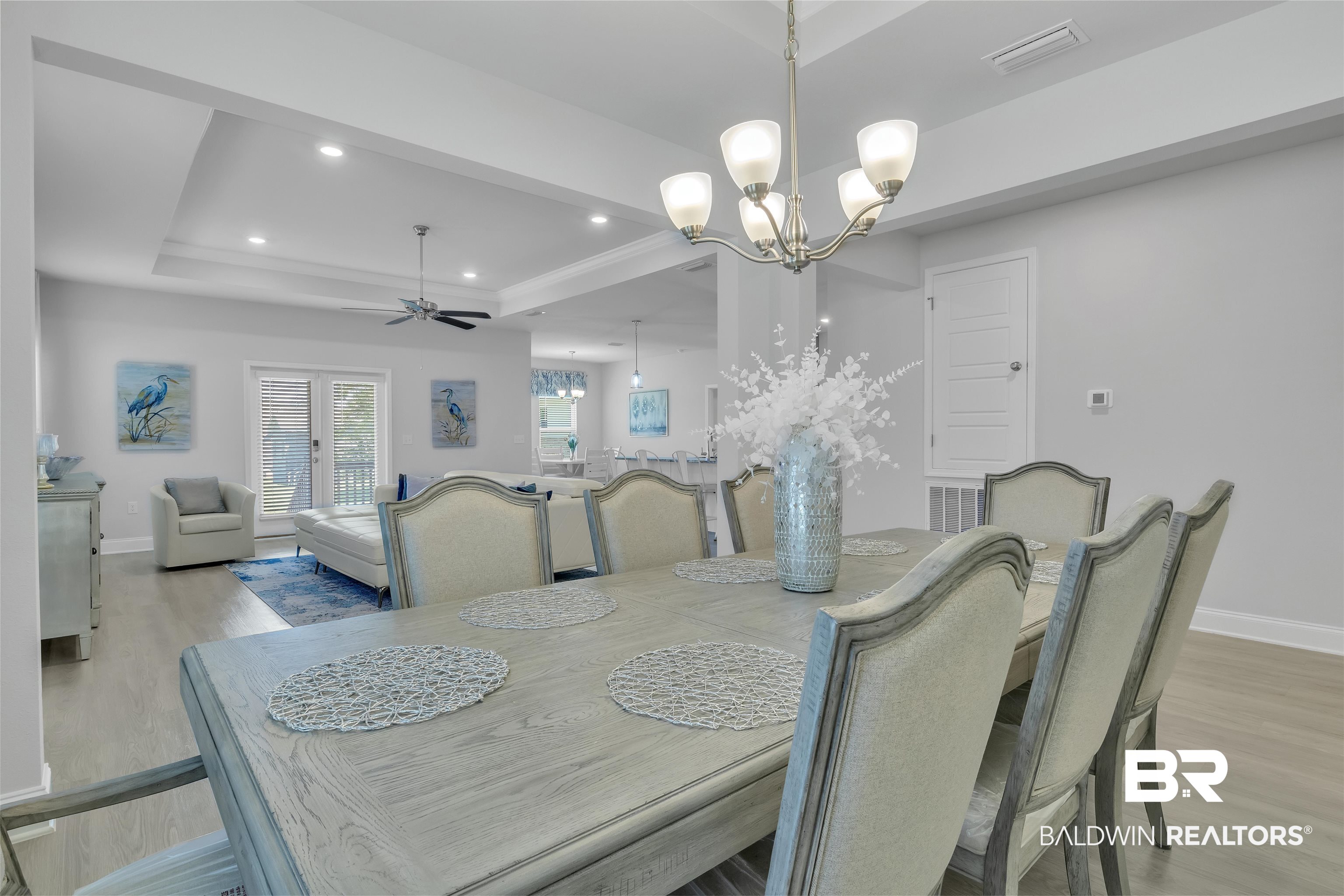 27862 Jade Court Daphne, AL 36526 - Photo 6 of 33 Dining area featuring ceiling fan with notable chandelier, light wood-style flooring, a raised ceiling, baseboards, and visible vents