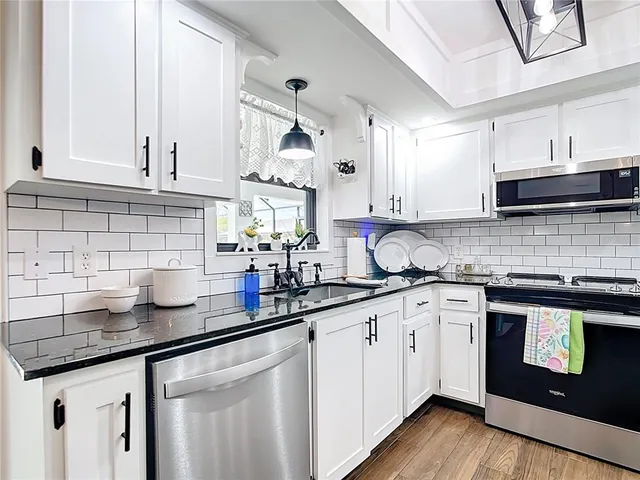 a view of a dining room with furniture a chandelier and wooden floor