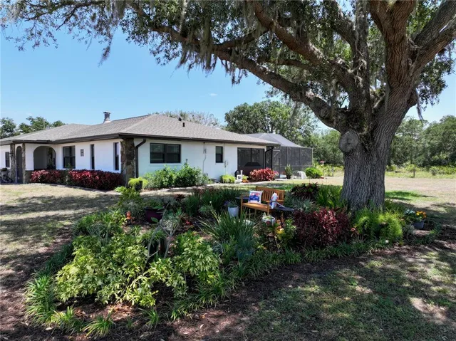 a view of a house with swimming pool and chairs