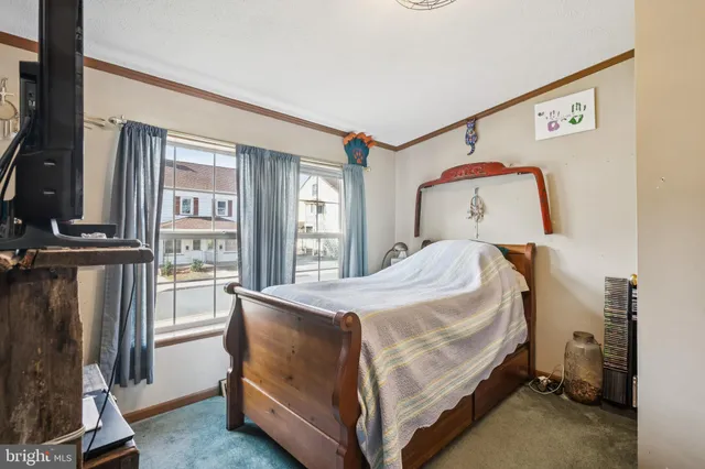 a bed sitting in a bedroom next to a window with a dresser