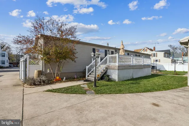 a view of a house with a yard and large tree