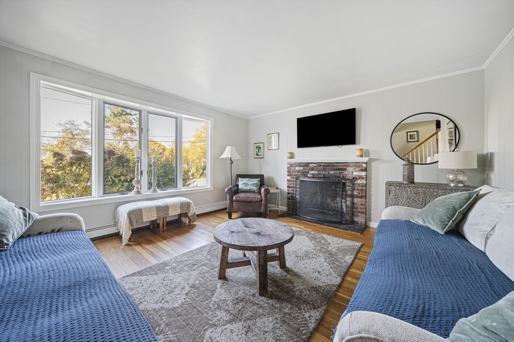417 Hatherly Road Scituate, MA 02066 - Photo 7 of 25 a living room with furniture a fireplace a flat screen tv and a large window