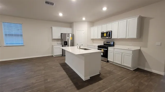 a kitchen with a refrigerator and a stove top oven