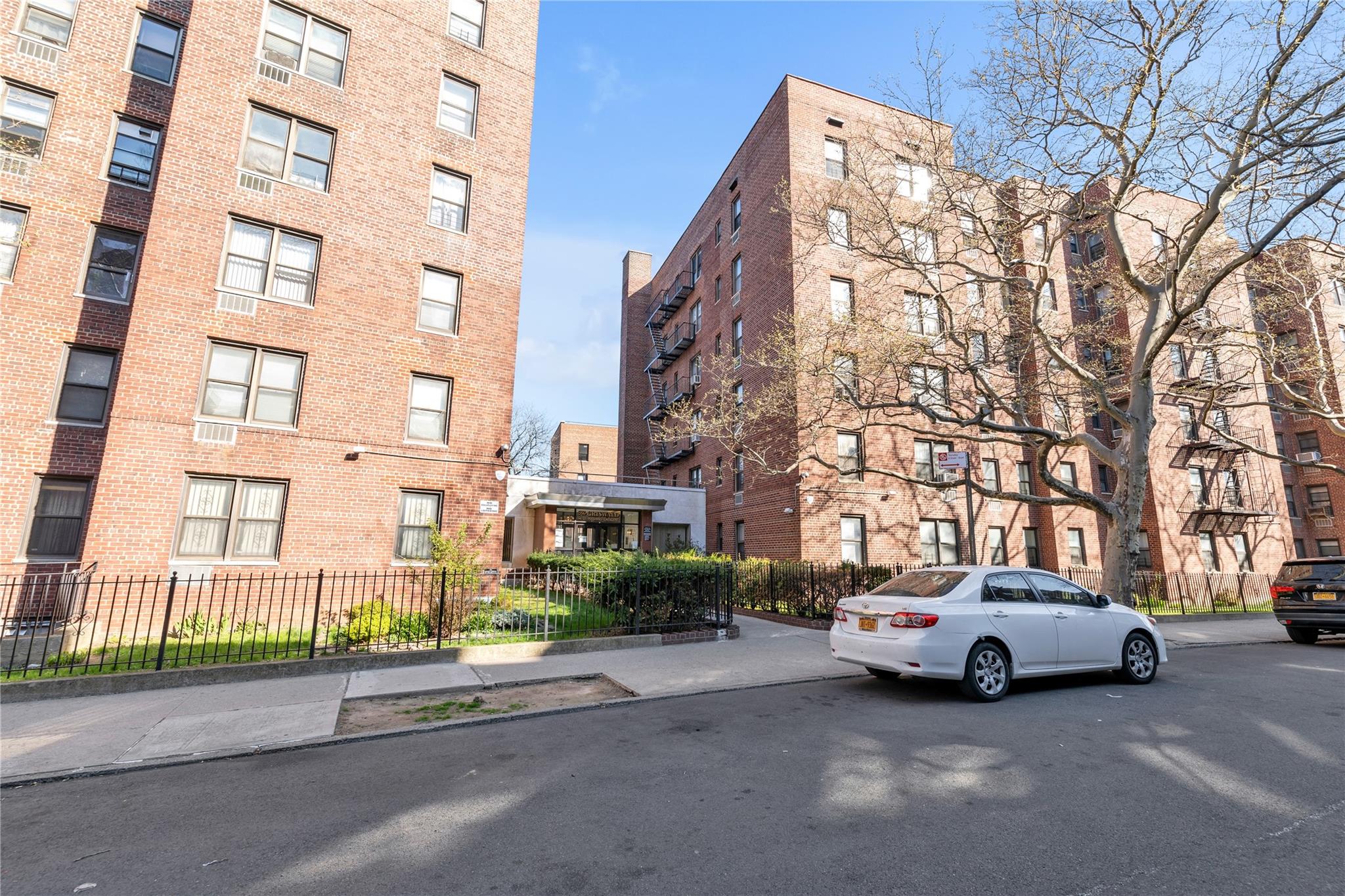 141-05 Pershing Crescent, Unit 117 Queens, NY 11435 - Photo 1 of 16 a white building that has a lots of windows in it