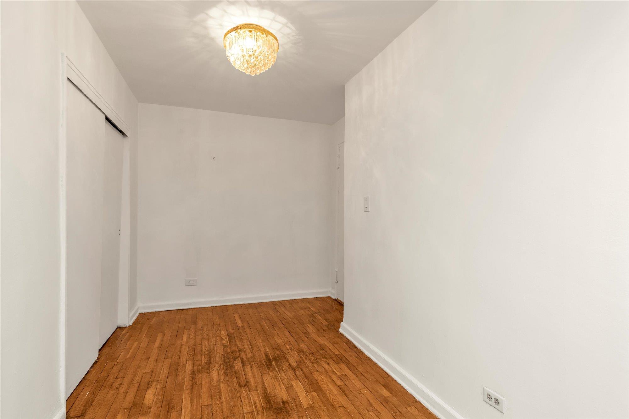 141-05 Pershing Crescent, Unit 117 Queens, NY 11435 - Photo 14 of 16 a view of a room with wooden floor and window