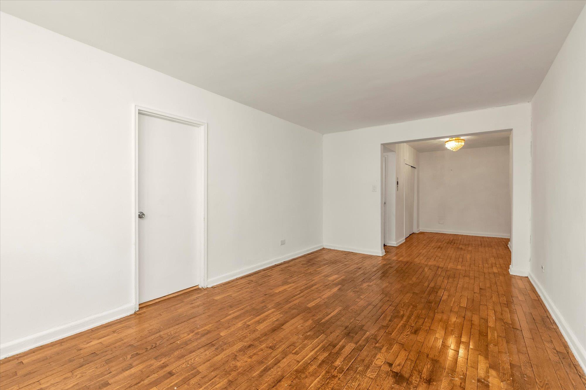 141-05 Pershing Crescent, Unit 117 Queens, NY 11435 - Photo 5 of 16 a view of empty room with wooden floor