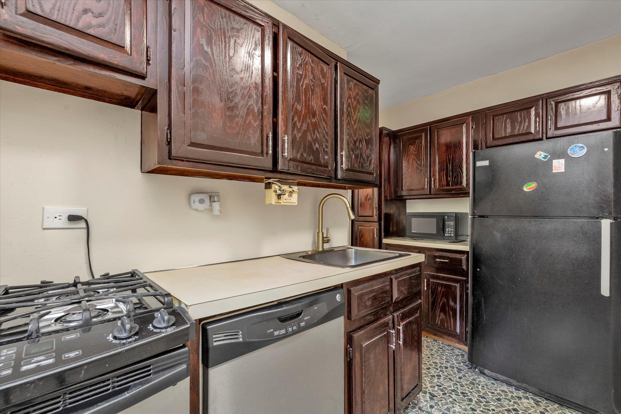 141-05 Pershing Crescent, Unit 117 Queens, NY 11435 - Photo 7 of 16 a kitchen with a stove and a refrigerator