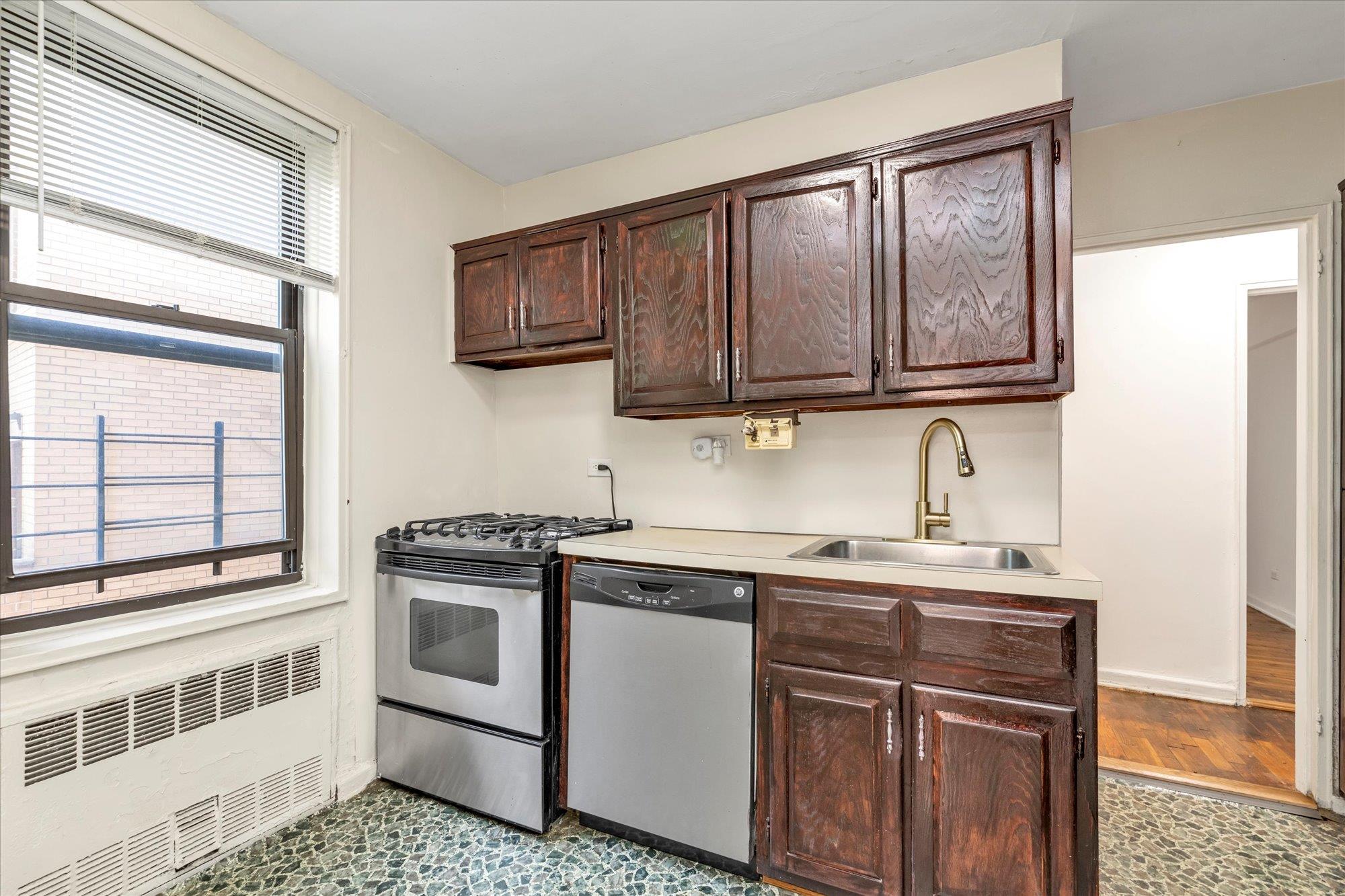 141-05 Pershing Crescent, Unit 117 Queens, NY 11435 - Photo 9 of 16 a kitchen with stainless steel appliances granite countertop a stove a sink and a microwave