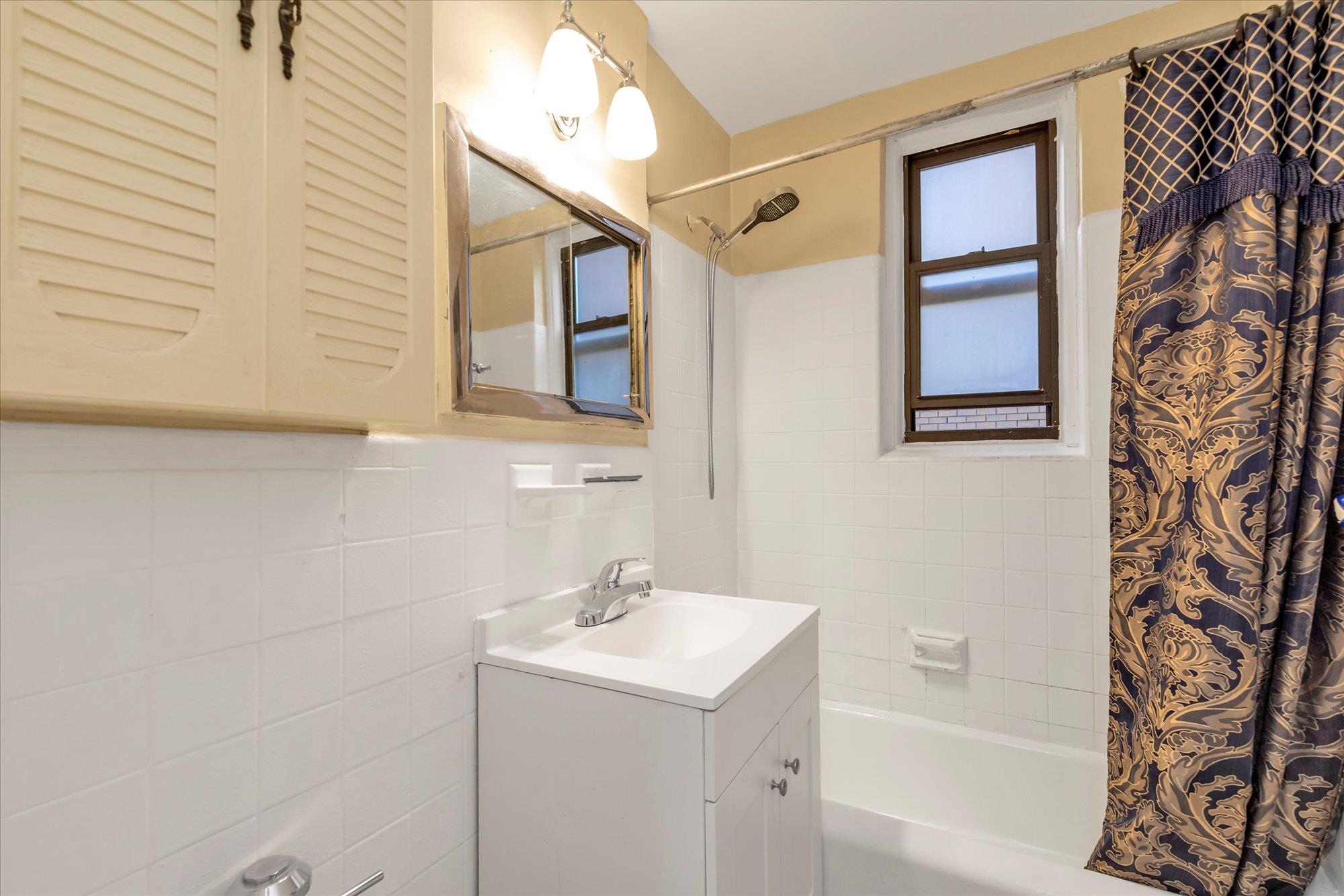 141-05 Pershing Crescent, Unit 117 Queens, NY 11435 - Photo 10 of 16 a bathroom with a sink a toilet and shower