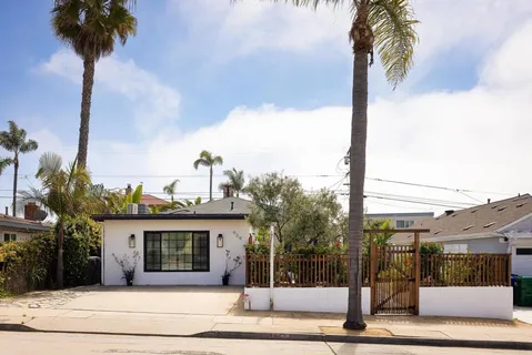 a view of a house with a yard and palm trees