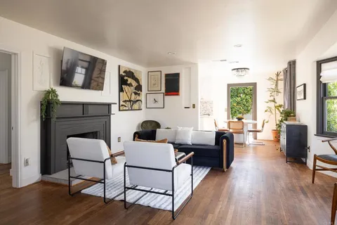 a living room with fireplace furniture and a wooden floor